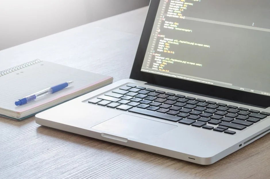 Man working on web design at home office setup with dual monitors.